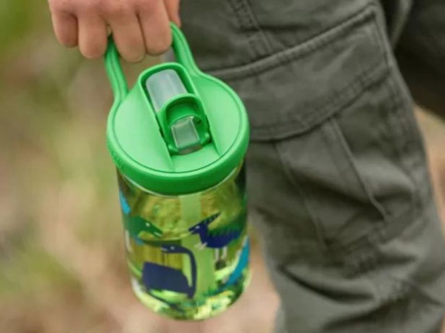 A child holding a Camelbak Eddy Dinosaur with straw