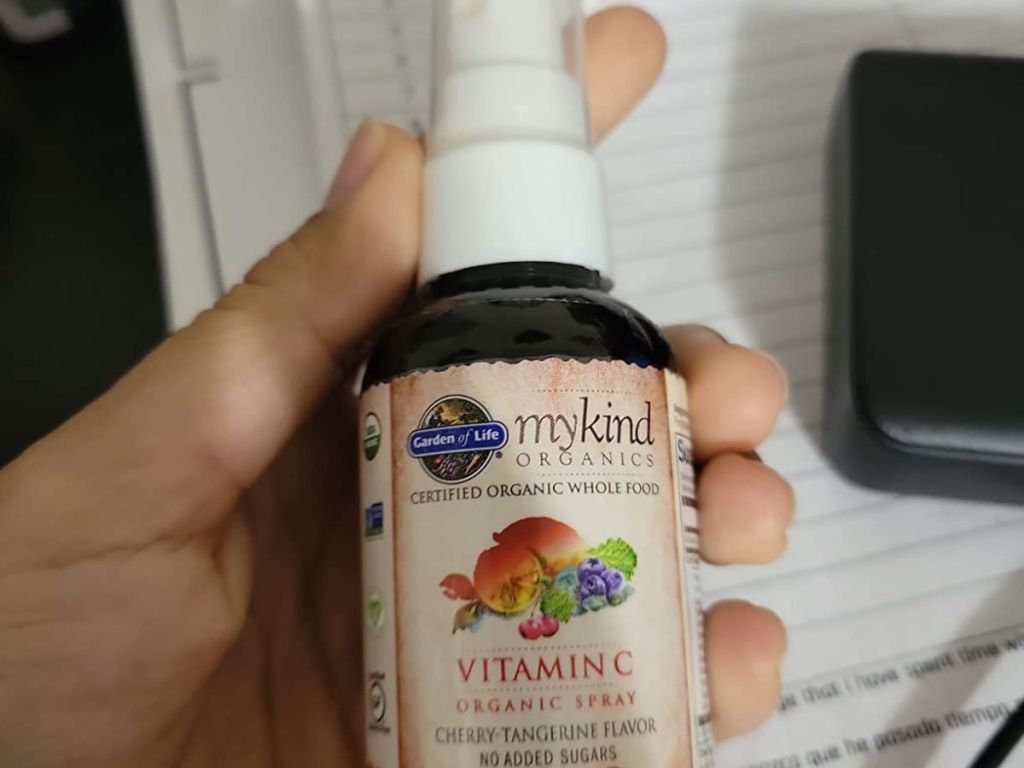 Hand holding a bottle of Garden of Life Vitamin C Spray