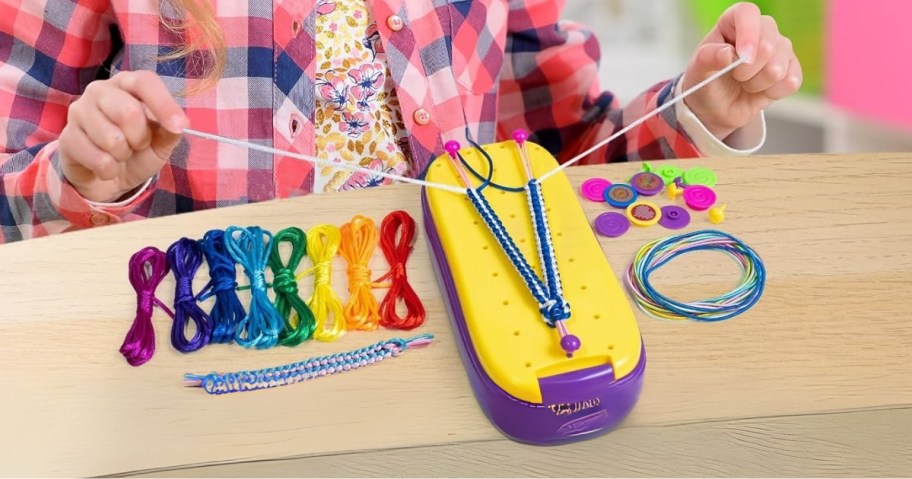 girl making friendship bracelets with a loom kit