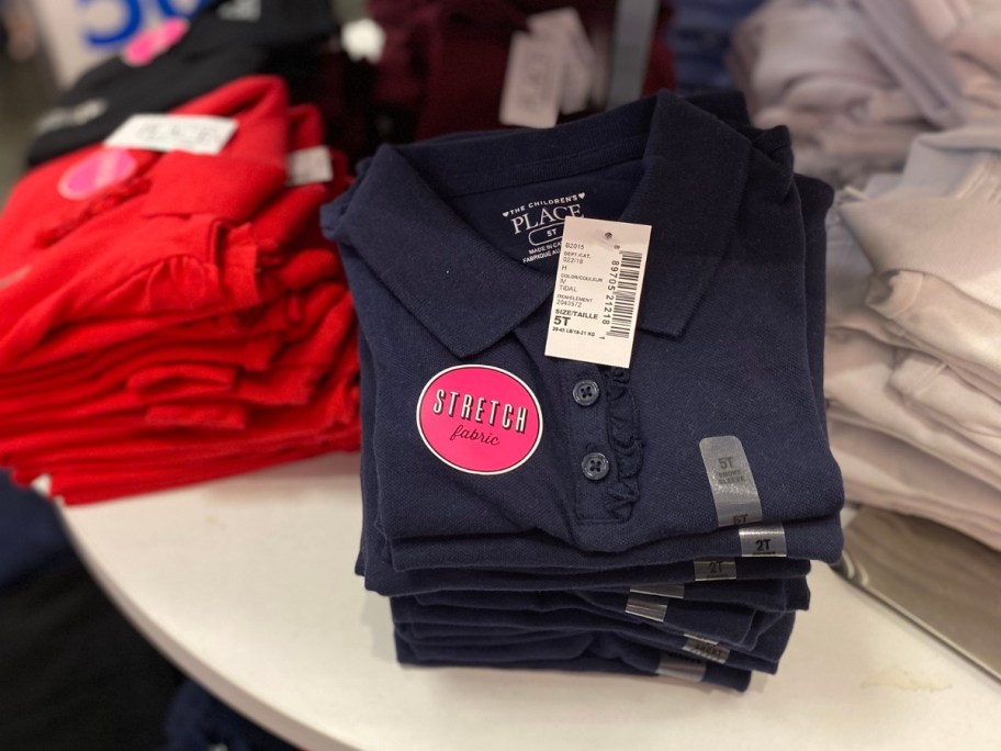 red, blue and white kid's uniform polos on display at The Children's place