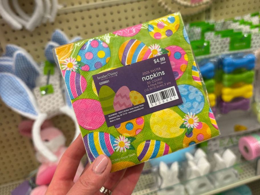 Hand holding a pack of Hobby Lobby Patterned Eggs Napkins 