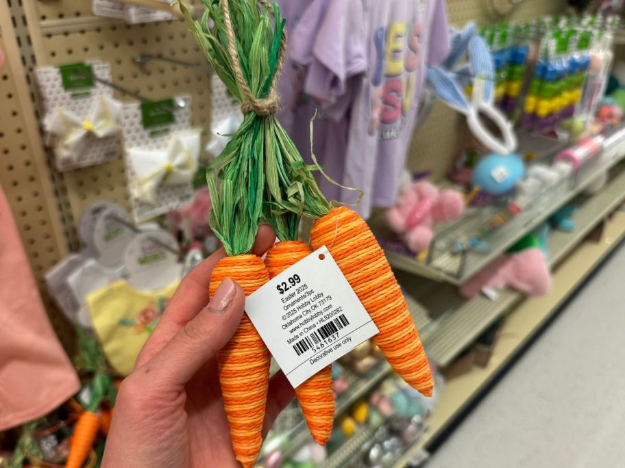 Hand holding a HObby Lobby Carrot Bundle Ornament