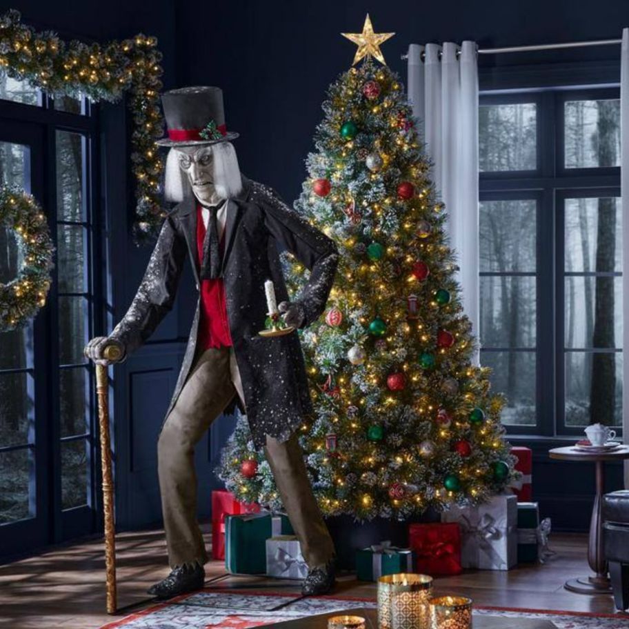 animatronic scrooge next to a decorated christmas tree