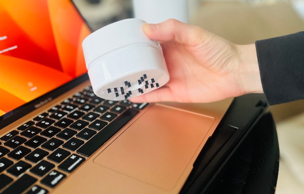 hand holding white keyboard vacuum cleaner