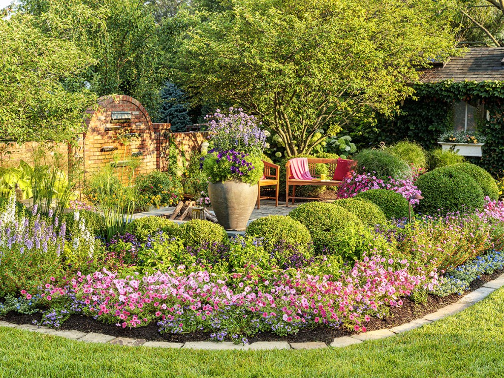 colorful garden in backyard with sitting area in center