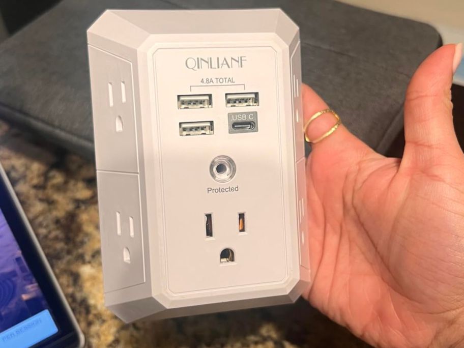 Hand holding a QINLIANF Outlet Extender