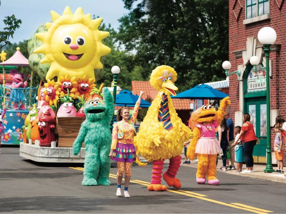 Sesame place parade with big bird walking down the street