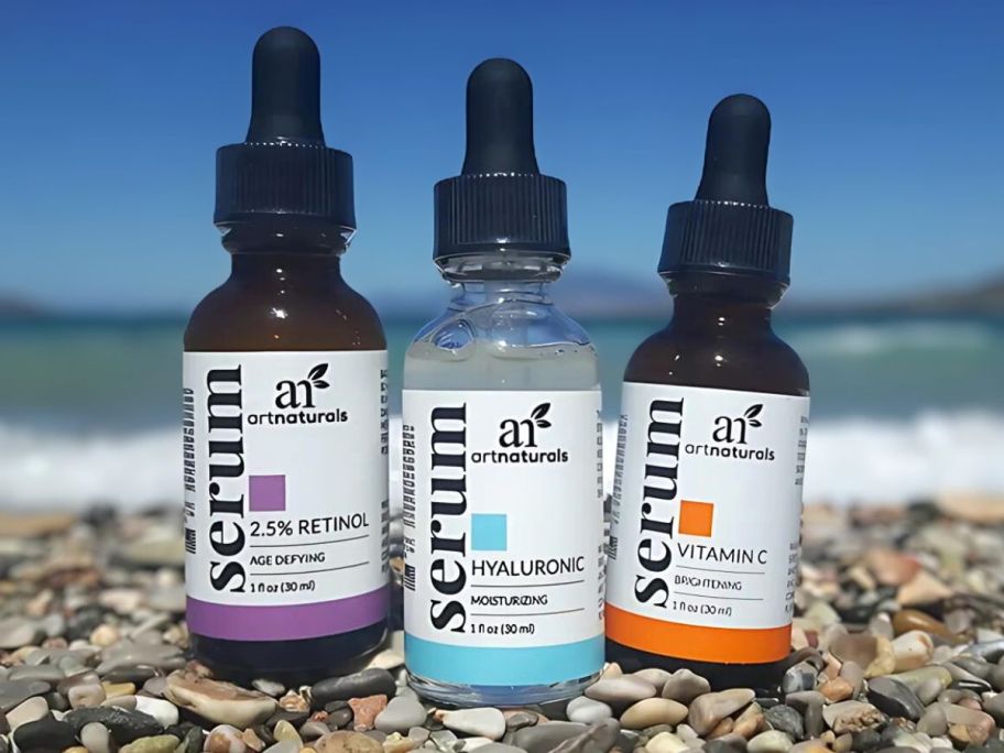 3 artnaturals serum sitting on stones near beach