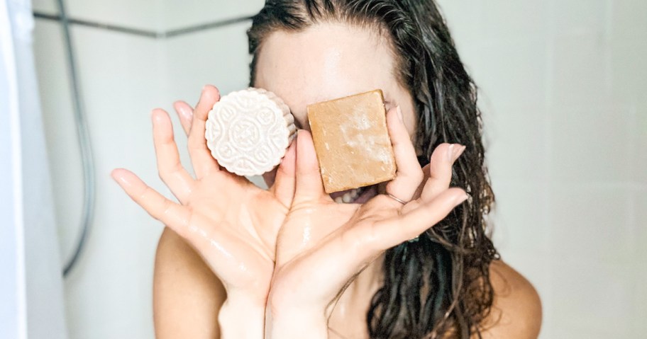 woman holding bar shampoo and conditioner to eyes