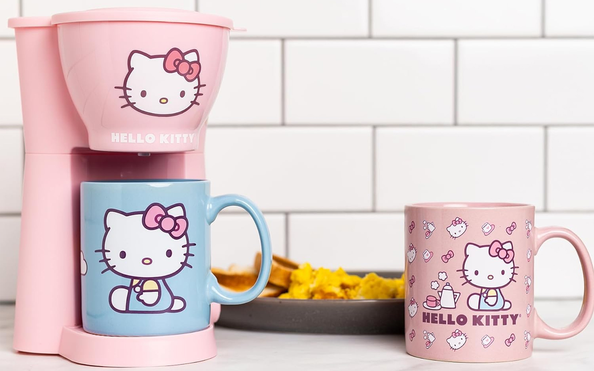 pink hello kitty coffee maker with blue coffee mug on table with pink mug 