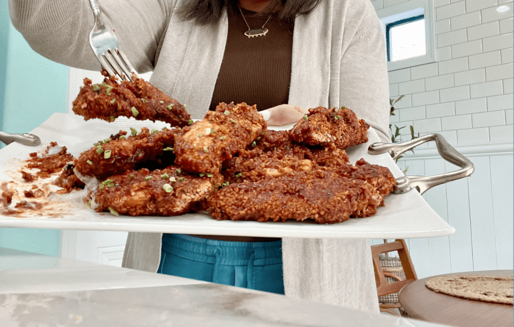 holding a tray of honey sriracha chicken tenders