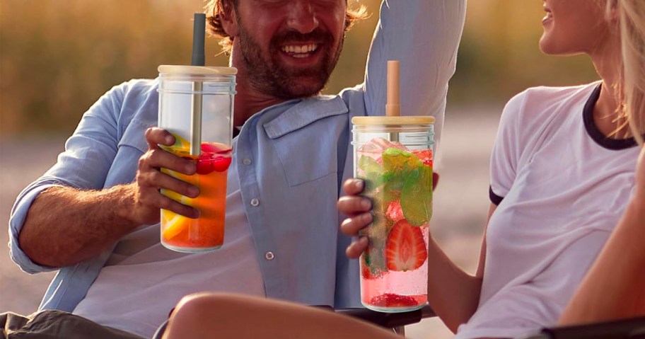 man and women drinking out of mason jar glasses