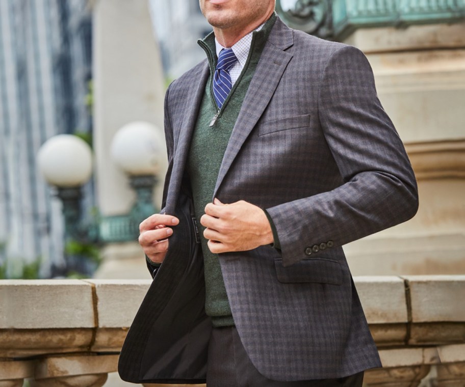 man adjusting sportcoat walking outside