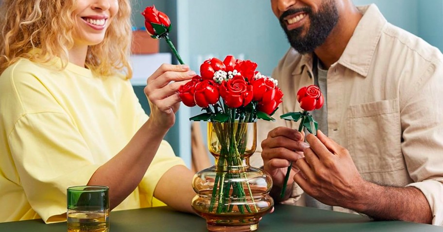 man and woman putting lego roses into vase