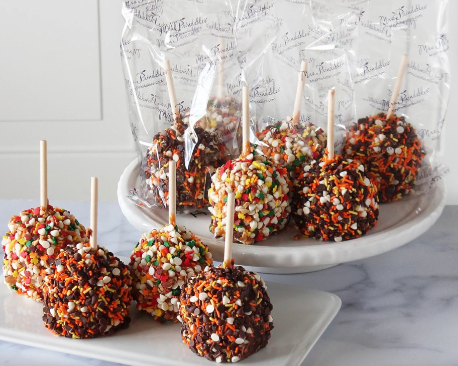 many fall caramel apples on cake stand and tray