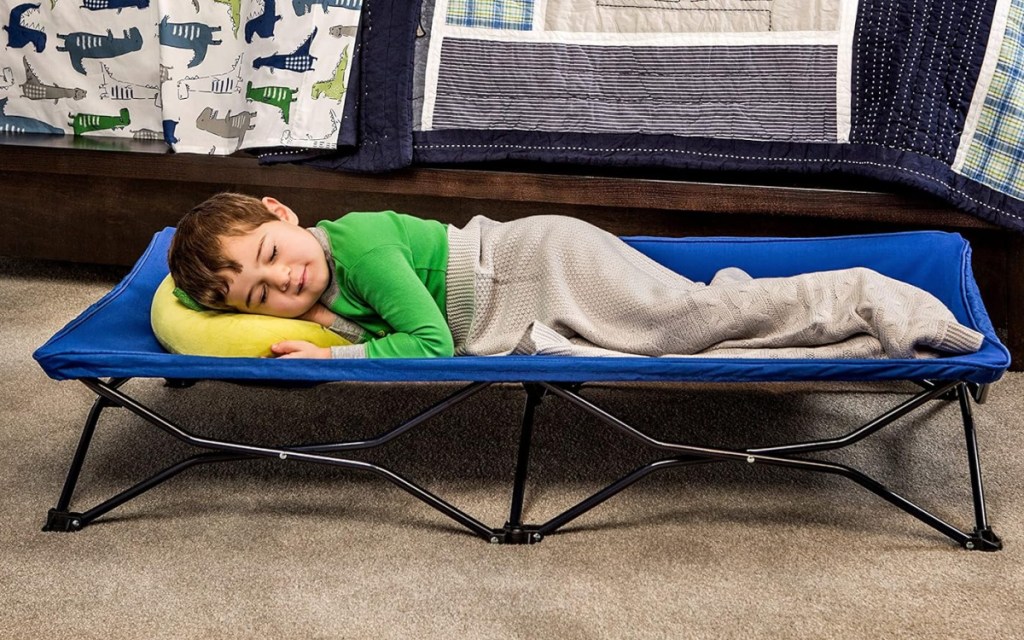 boy sleeping in travel cot