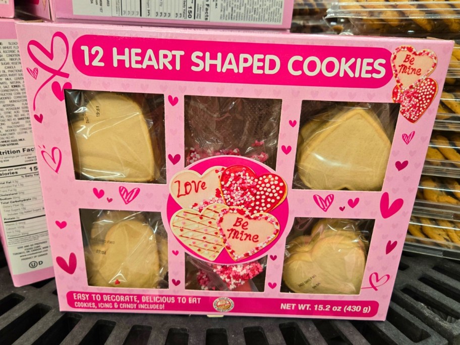 a pink box of Valentine's Day heart shaped cookies with a cookie decorating kit