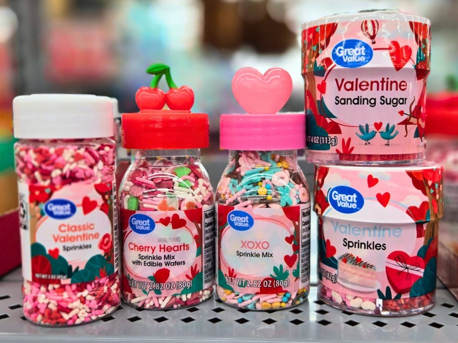 various Valentine's themed sprinkles in containers on a store shelf