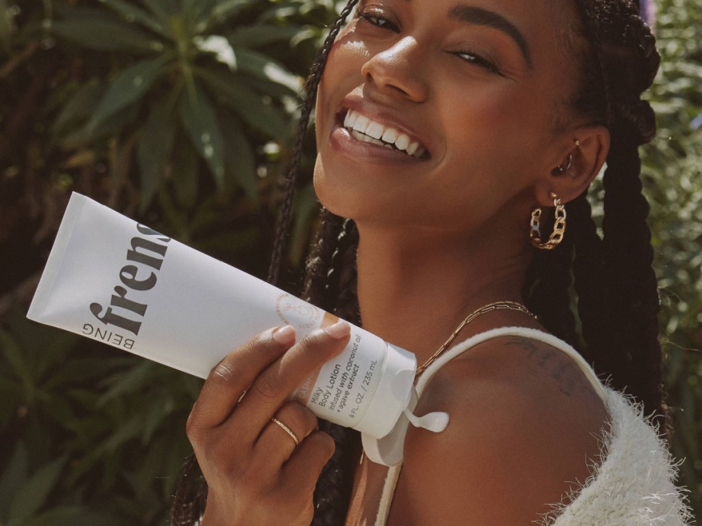 woman using being frenshe body lotion on her shoulder