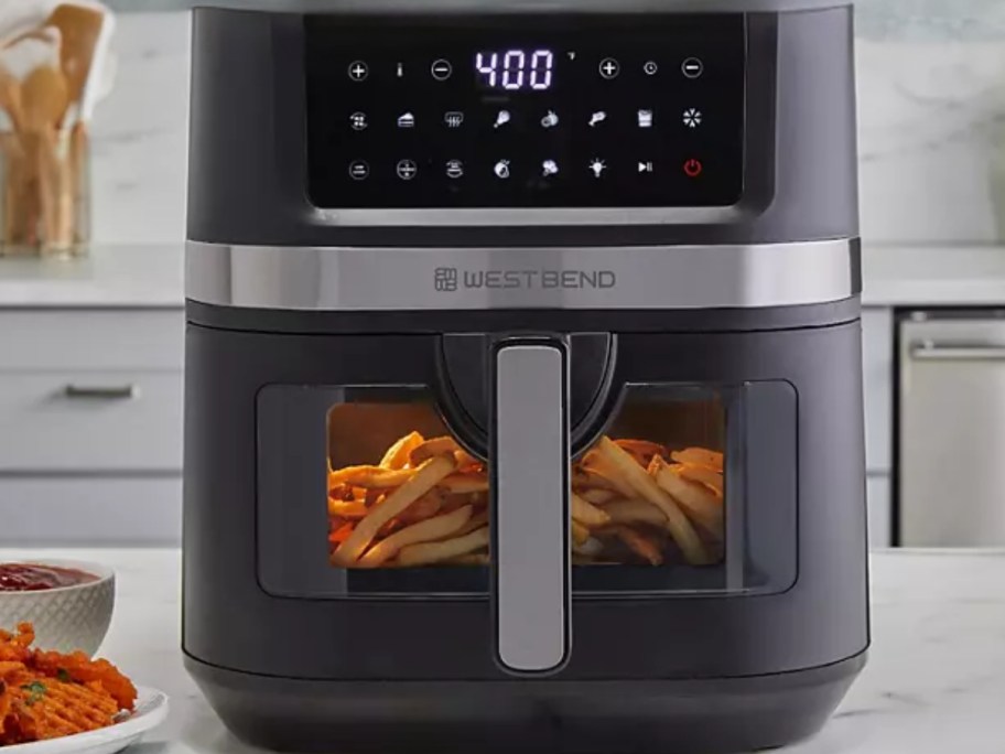 large black air fryer with food in it on a kitchen counter