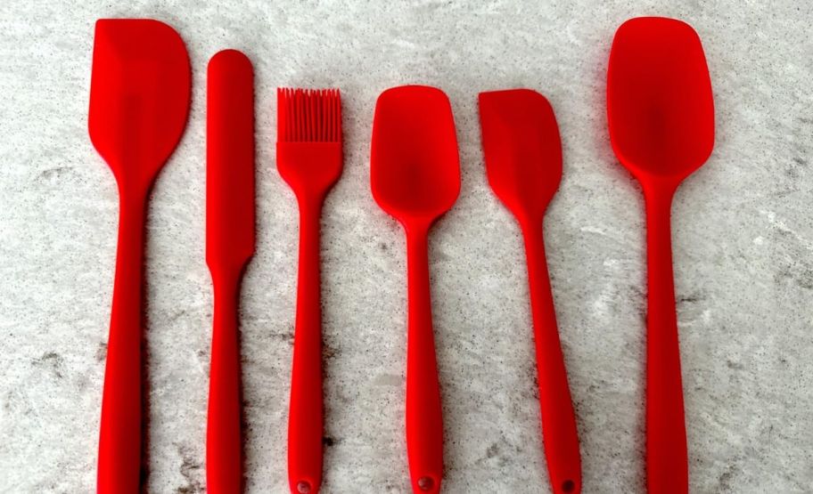 a red 6 piece silicone spatula set on a white marble counter