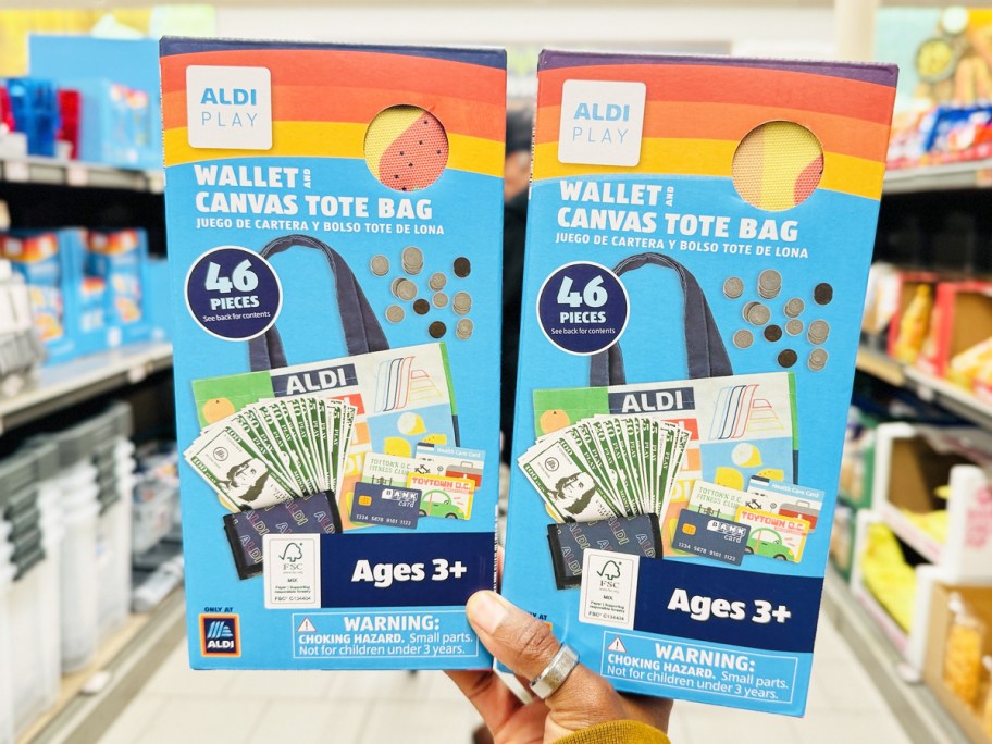 hand holding up two ALDI Kids Wallet & Tote Bag Play Sets