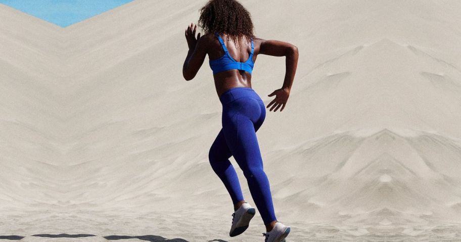 Woman running on sand wearing allbrids clothing