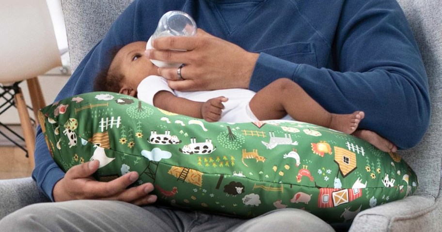 feeding baby resting on a green Boppy Nursing Pillow