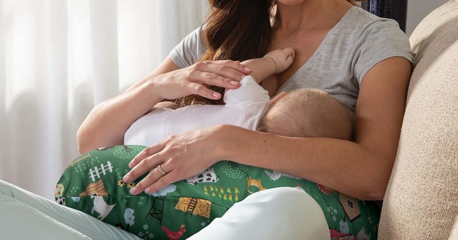 feeding baby resting on a green Boppy Nursing Pillow