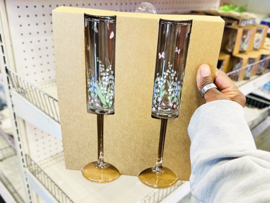 hand holding up s set of floral print champagne flutes