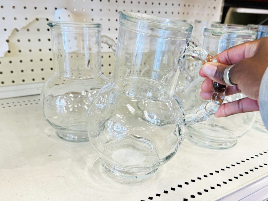 hand grabbing a glass pitcher from store shelf