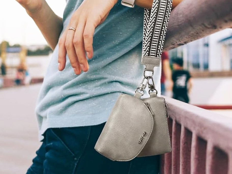 woman with a grey dual pouch keychain wristlet hanging on her arm