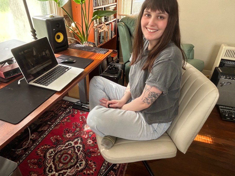 smiling woman sitting cross legged in one of the viral criss cross office chairs