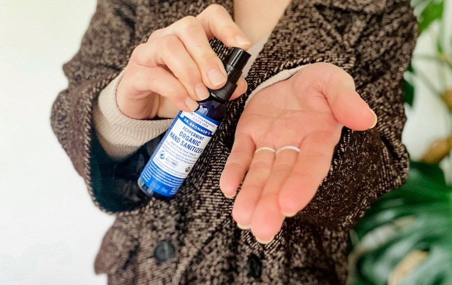 hand spraying dr. Bronner's organic peppermint hand sanitizer on hands