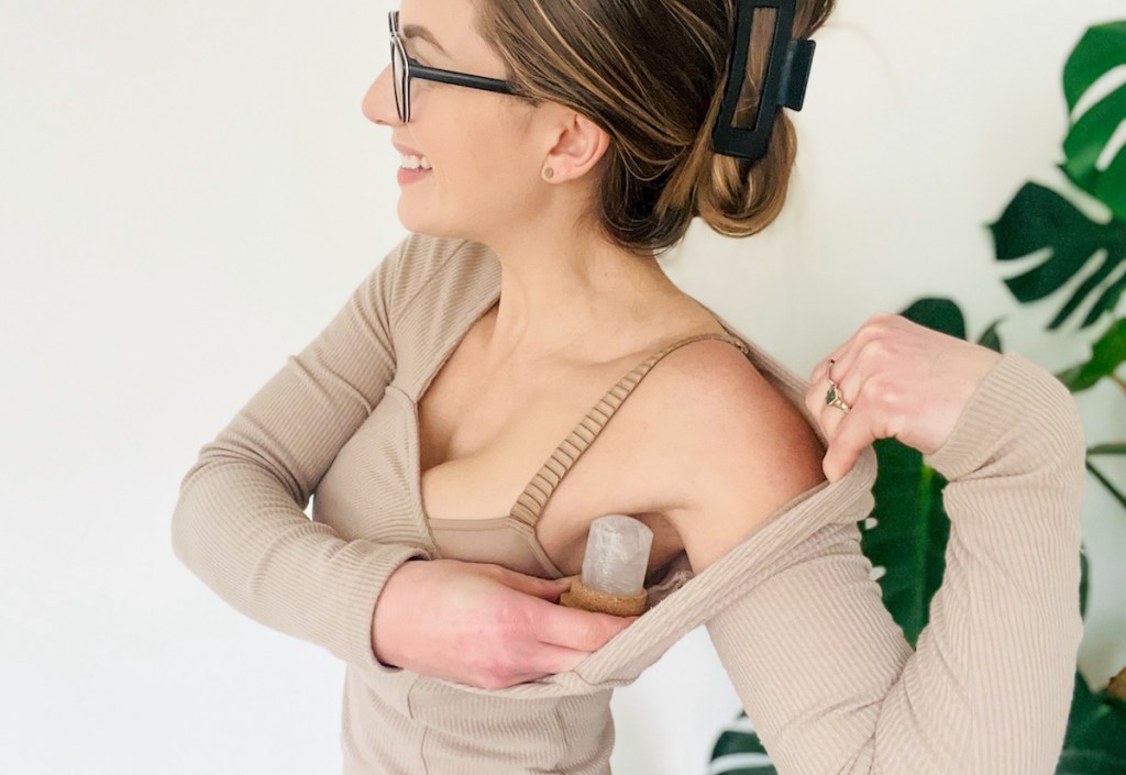 Woman holding crystal deodorant, stick under armpit 