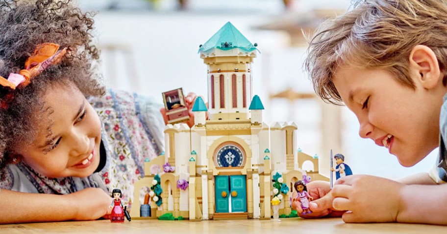 girl and boy playing with lego disney castle building set