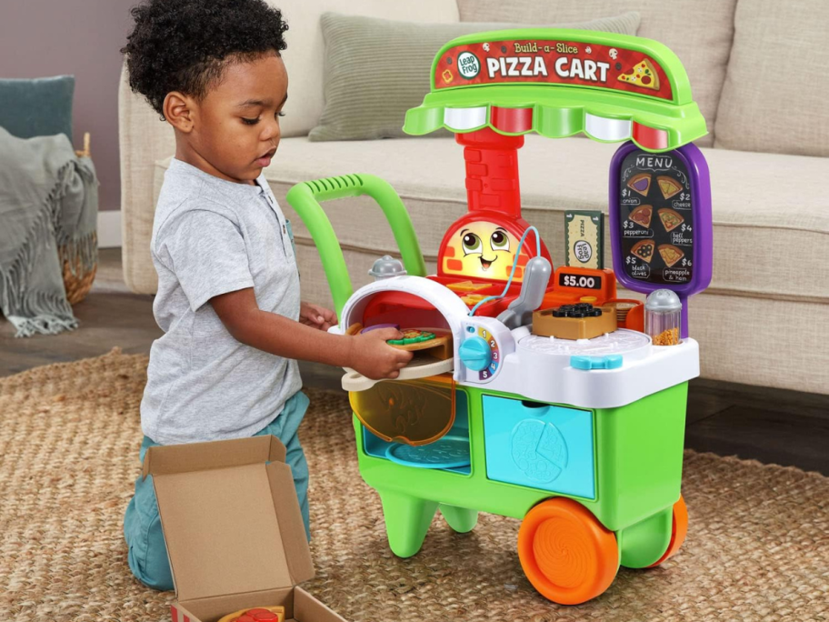 A child playing with a LeapFrog Build-a-Slice Pizza Cart 