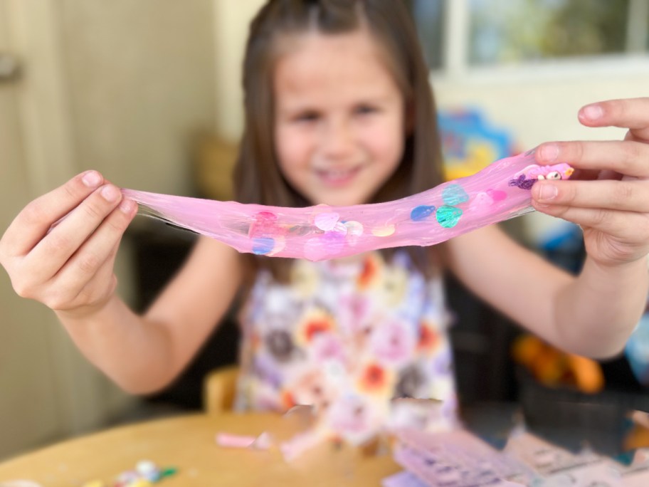 Young girl playing with pink slime