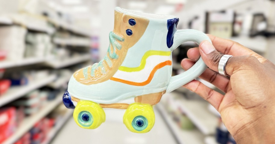 hand holding up a roller skate shaped coffee mug