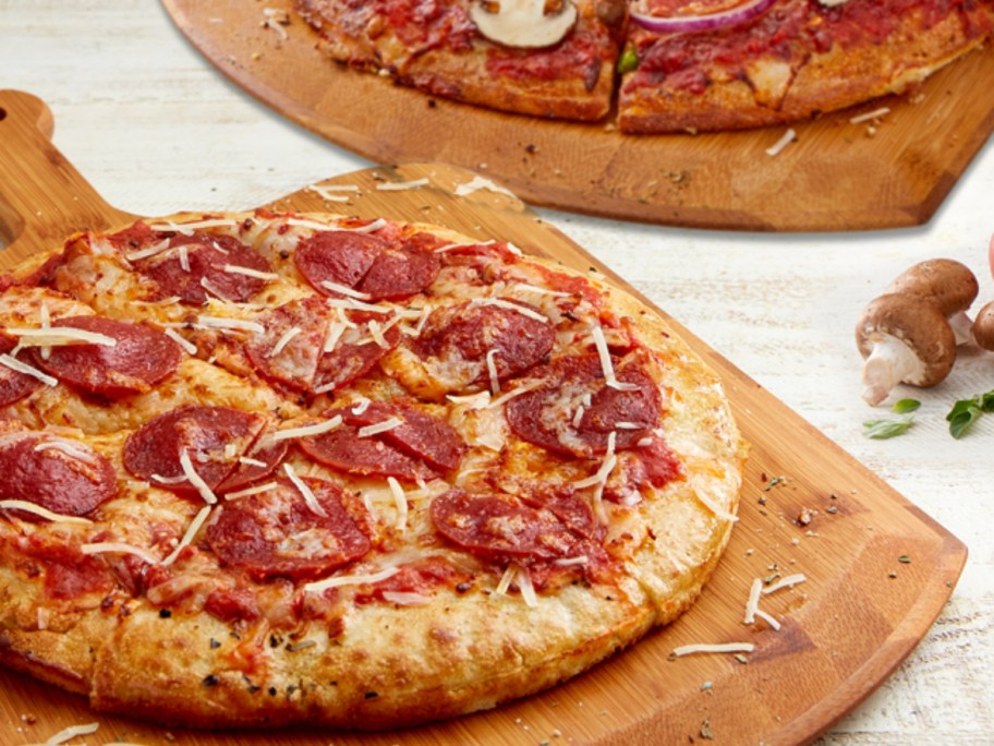 2 pizzas on wooden boards