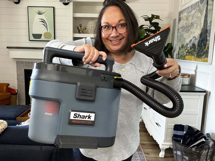 woman holding up Shark Messmaster wet/dry vacuum