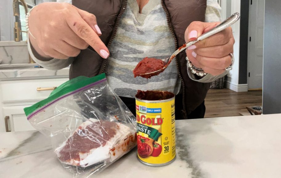 woman demonstrating how to freeze tomato paste, one of our favorite kitchen and food hacks