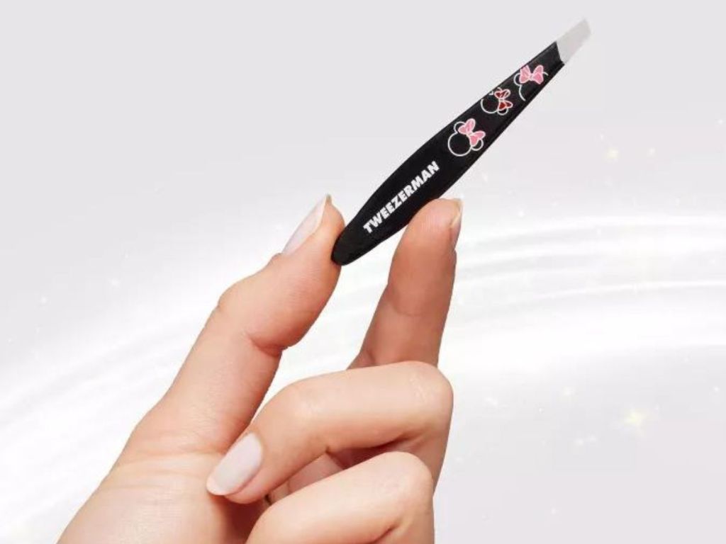 Hand holding a pair of Tweezerman Minnie Mouse mini tweezers