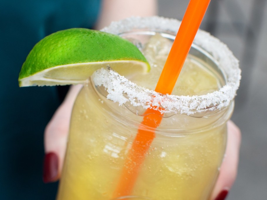 holding a margarita in a mason jar