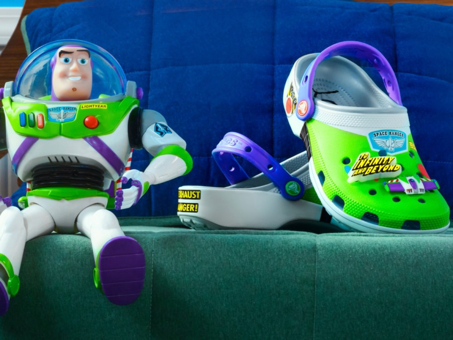 buzz lightyear crocs sitting next to buzz action figure on blanket