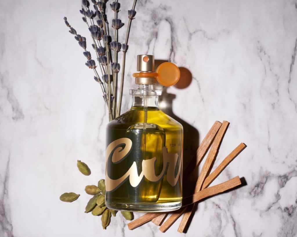 cologne bottle on pile of lavender and sticks