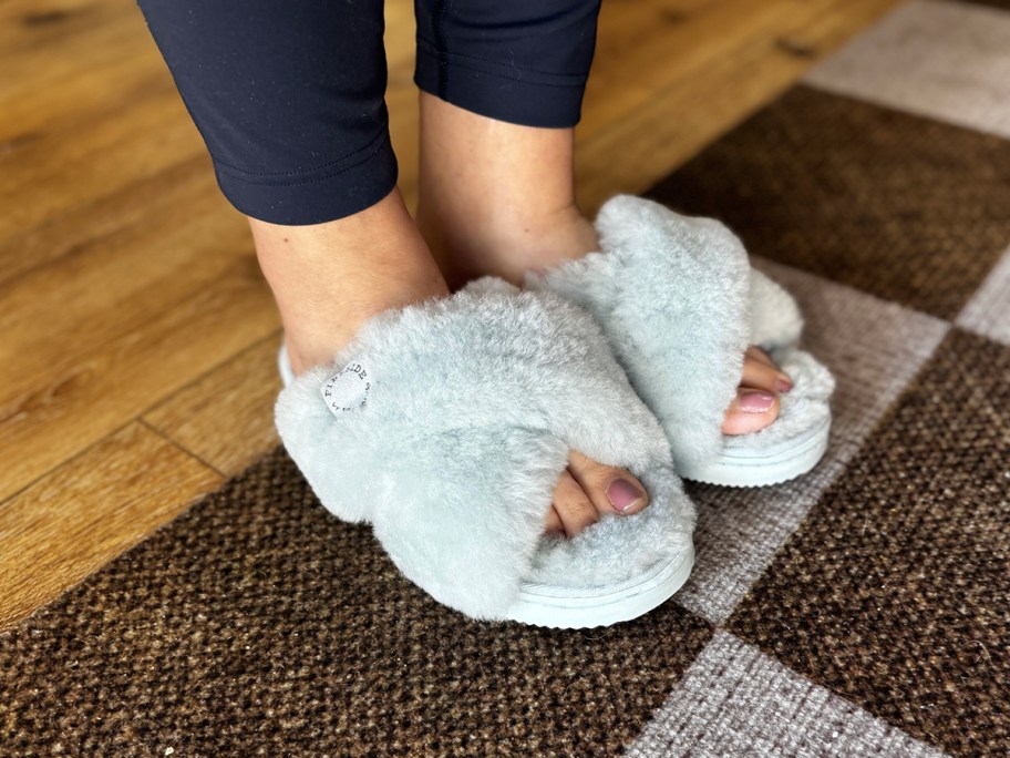 woman wearing dearfoams fireside light blue plush slippers