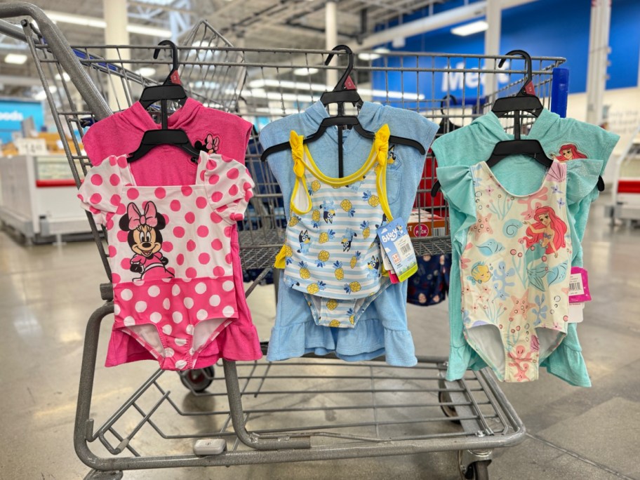 display of girl Disney and bluey bath suit sets hung on Sams club cart