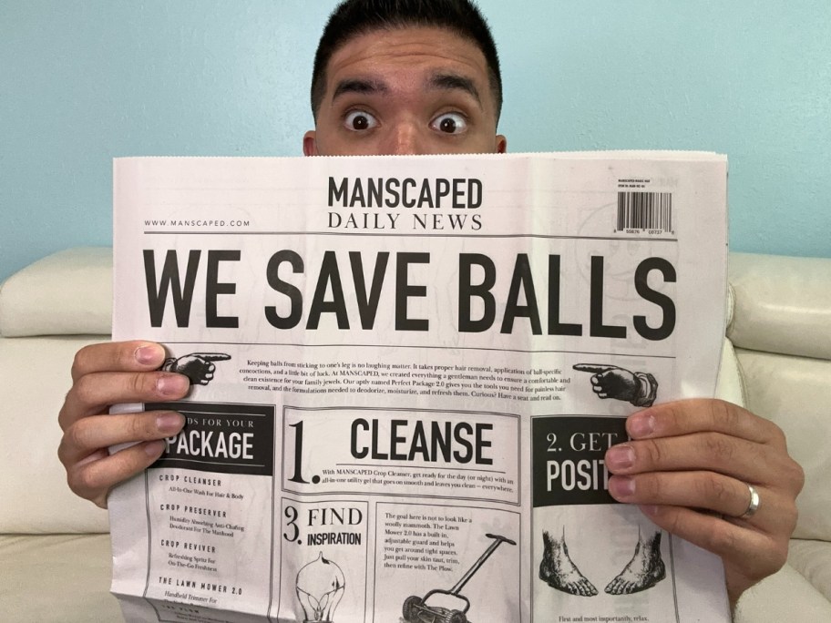 man holding a news paper with a look of surprise in his eyes