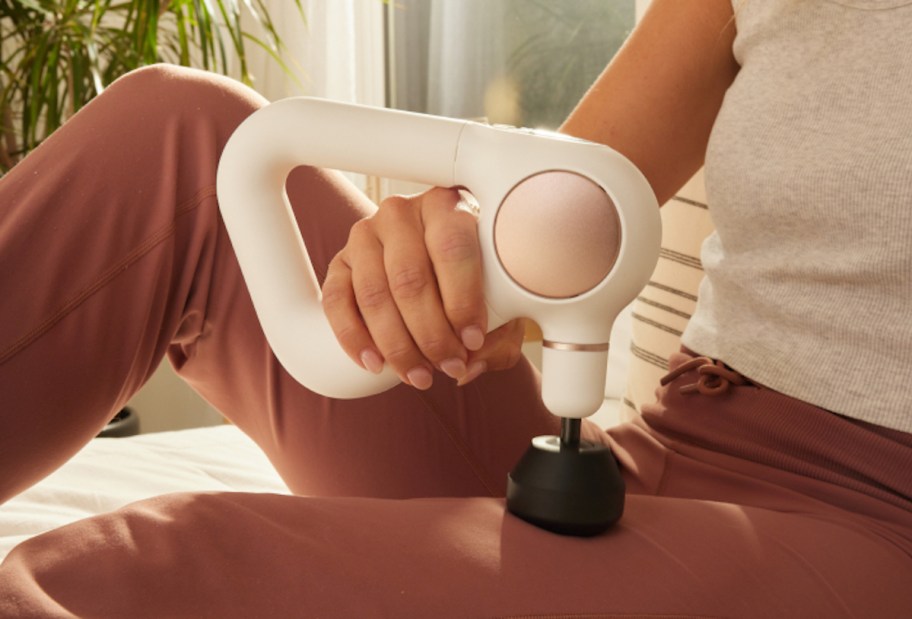 woman holding white massage gun